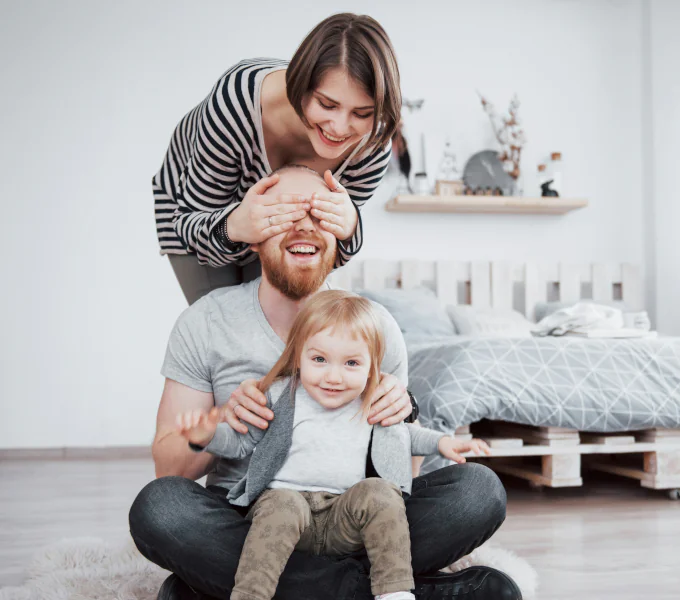 Young family with child laughing and playing at home