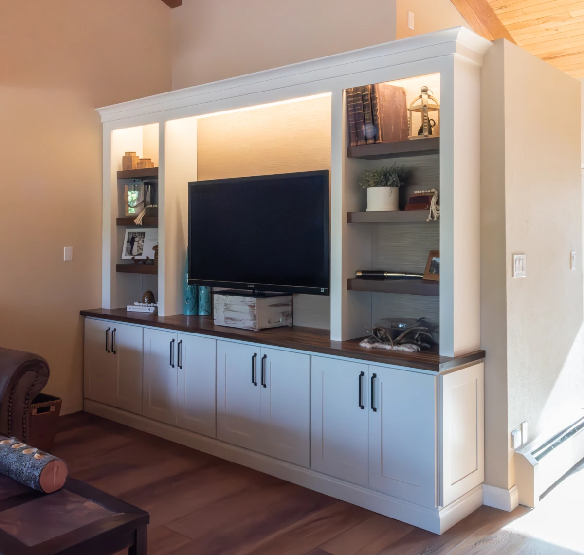 Custom built-in TV cabinetry with shelving and wood countertop for a modern home interior by Elite Cabinetry & Granite in Denver.