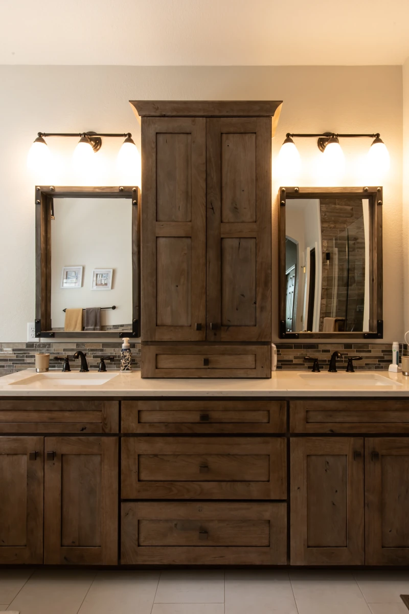 Bathrooms 1 Bathroom with rustic wood double vanity, center tower cabinet, quartz countertops, two undermount sinks, matte black faucets, framed mirrors, mosaic tile backsplash, and wall sconces.