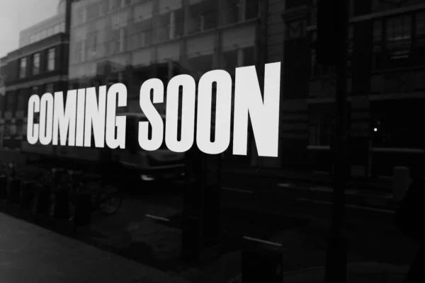 Black and white Coming Soon sign displayed on a reflective storefront window, used as a placeholder image for upcoming residential remodeling Denver content.