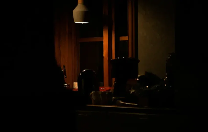 The Psychology of the Midnight Snack: Why Your Kitchen Layout Design Actually Matters at 2 AM 1 A warm, dimly lit kitchen with wood cabinetry and stainless steel appliances at night.