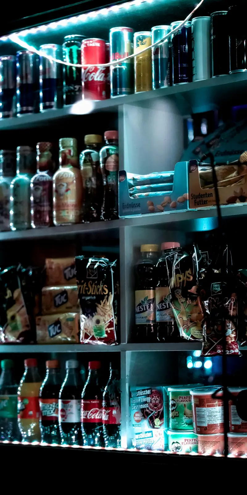 Shelf stocked with drinks, snacks, and LED lighting for easy late-night access.