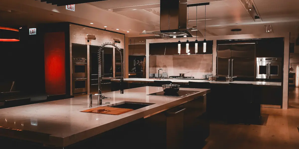 Modern kitchen featuring a large quartz island, stainless steel appliances, and soft ambient lighting to show how kitchen layout design actually matters.