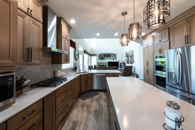 Natural wood kitchen with quartz countertops, stainless steel appliances, and large island, featured in our kitchen bathroom remodeling process Denver project.
