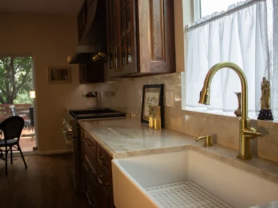 Burnished Grain Kitchen 15 kitchen-farmhouse-sink-gold-faucet-walnut-cabinets-patio-view