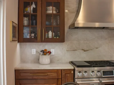 Burnished Grain Kitchen 3 walnut-glass-front-upper-cabinets-stainless-range-hood-marble-backsplash