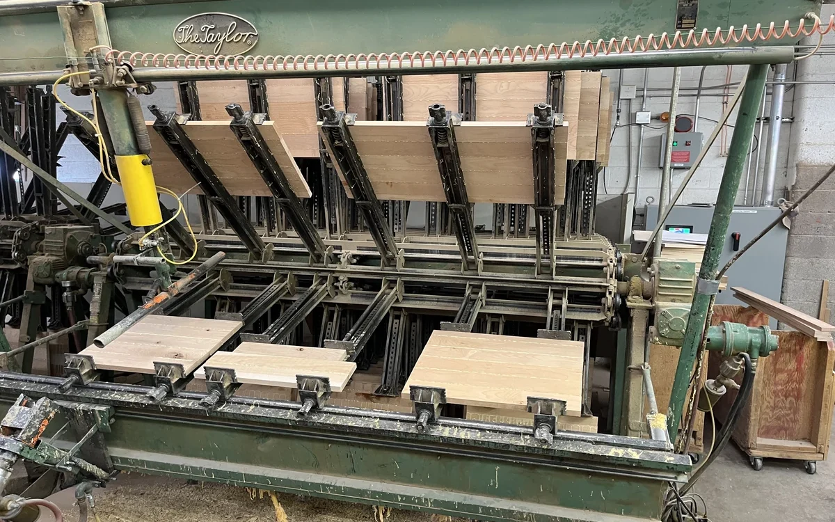 Your Denver Kitchen Remodel Guide: Custom Work, Fast Timelines, and a Kitchen You Will Actually Love 1 Industrial glue press machine assembling custom wood cabinet panels in a Denver cabinetry workshop.