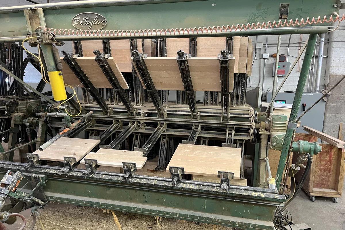 Your Denver Kitchen Remodel Guide: Custom Work, Fast Timelines, and a Kitchen You Will Actually Love 7 Industrial glue press machine assembling custom wood cabinet panels in a Denver cabinetry workshop.