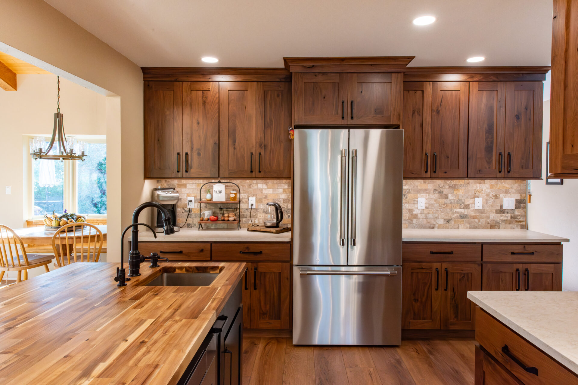 Porcelain Countertops Denver Homeowners Are Falling For: The Low-Maintenance Trend for Indoor and Outdoor Kitchens 4 Rustic wood kitchen cabinets with a butcher block island, farmhouse-style sink, and stainless-steel refrigerator in Denver