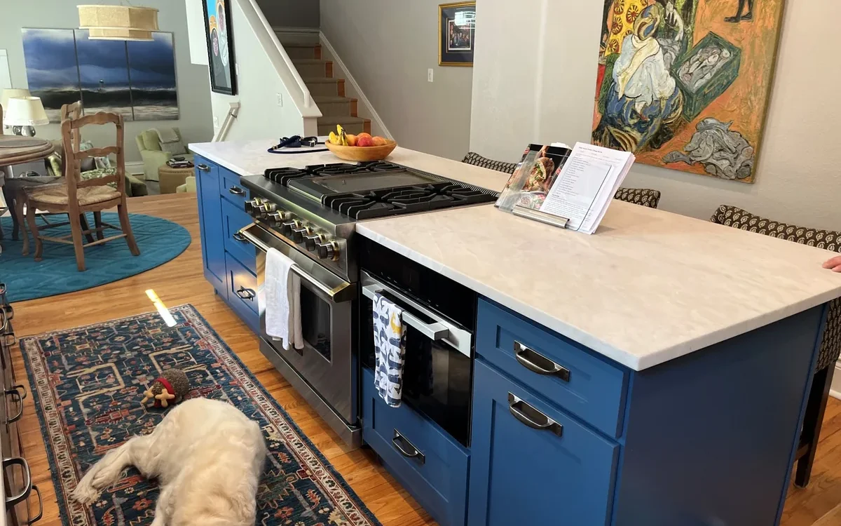 Porcelain Countertops Denver Homeowners Are Falling For: The Low-Maintenance Trend for Indoor and Outdoor Kitchens 1 Large blue kitchen island with a white marble-look countertop, professional range, and built-in microwave