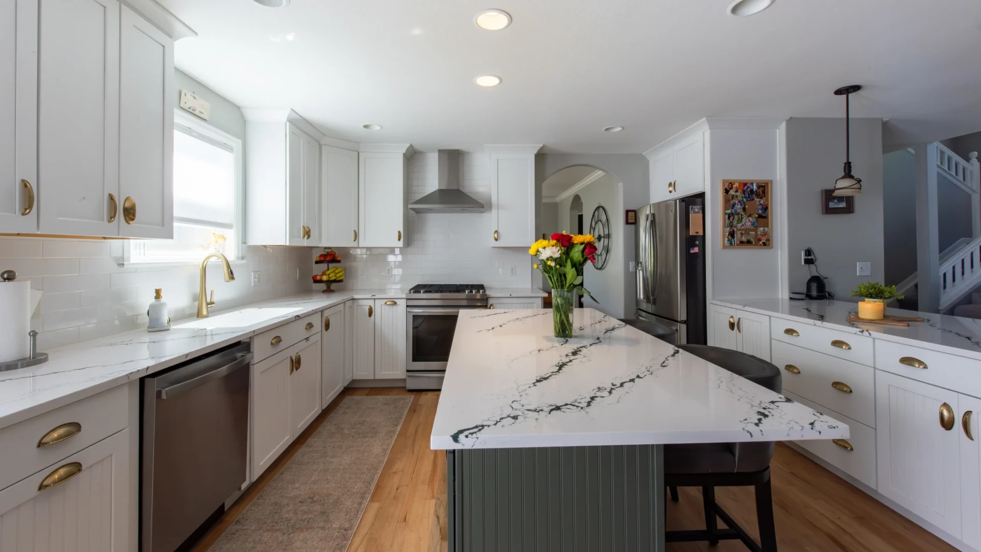 Quartz countertop tariff 2026 article image showing a Denver kitchen with white cabinets and a large quartz countertop island